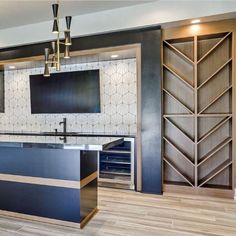 a kitchen with an island in the middle and cabinets on both sides, along with a television mounted to the wall