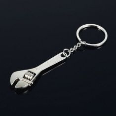 a wrench shaped key chain on a black background