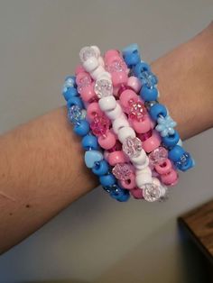 a person's arm with bracelets made out of plastic beads and other items