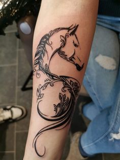 a woman's arm with a horse tattoo on it