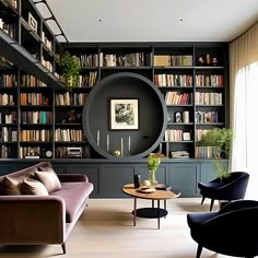 a living room filled with furniture and bookshelves covered in lots of bookcases