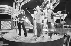 the rolling stones performing on stage in front of an audience at a concert with microphones