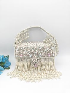 "Premium Quality Heavy Rhinestones Beaded Handmade  Wedding Purse The purse has beautiful beadwork. The purse is made of velvet and heavily beaded with rhinestones all over. The team of artisans has done a fantastic job. These bags are ideal for wedding functions, but you can also have them daily. These are ideal for parties, receptions, and gifts. These are small fancy bags designed for putting money, coins, and make-up touch-up kits.  The bag is heavy and one of a kind. It has a heavily beaded Beaded Clutch Purse, Embroidered Purse, Bridal Handbags, Wedding Bags, Afghan Jewelry, Purse White, Beautiful Beadwork, Wedding Purse, Party Purse