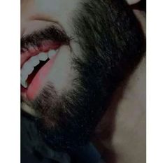 a bearded man with his mouth open and tongue out