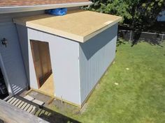 a small shed with the door open in front of a house that is being built