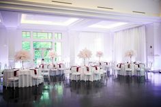 a room filled with lots of white tables and chairs