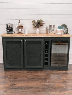 an entertainment center with black cabinet and wooden top