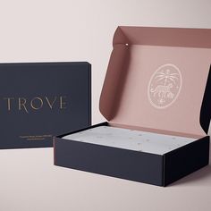 an open box with the lid opened and inside it, sitting on a table next to another box that says trove