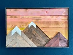 an art piece made out of wood with mountains painted on it