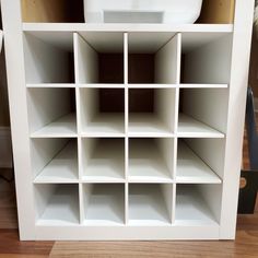 a white bookcase with many shelves on top of it and a bowl in the middle