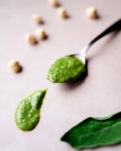 a spoon with some green food on it