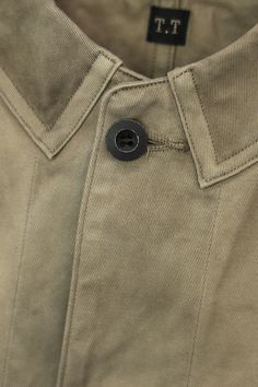 This redesigned coverall is based on the workwear worn by British railroad workers in the 1940s. Features such as the sewn-on collar and reinforcement stitching on the waist pockets are typical of British workwear from that era. The original change buttons have been replaced with metal buttons, matching LOT.214 as a coordinated ensemble. The waist-point fabric is treated with LOGWOOD GRAY, a natural dye, and Amami Oshima’s mud dyeing, a common practice in British workwear of that time. Model is British Workwear, Ww2 Fashion, Amami Oshima, 2025 Design, Popeye Magazine, Native Son, Canoe Club, Fashion Elements, Design Philosophy