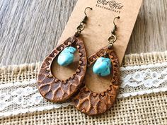 a pair of wooden earrings with turquoise beads