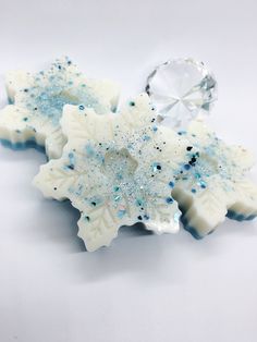 two snowflake shaped soaps sitting next to each other on a white surface