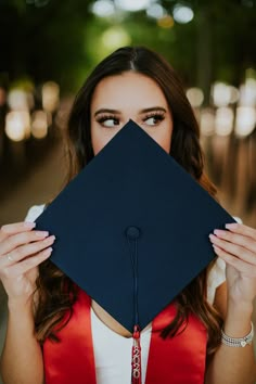 a woman holding up a graduation cap to her face