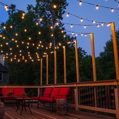 an outdoor deck with patio furniture and string lights strung across the entire length of it