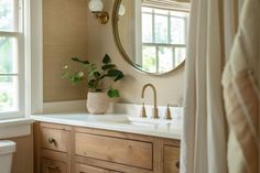 a bathroom with a sink, mirror and toilet in it's corner next to a window