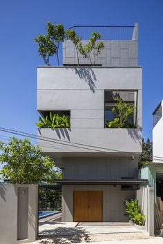 an apartment building with trees and plants growing on the top of it's windows