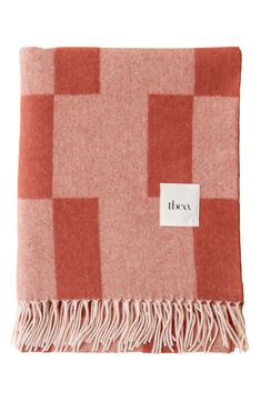 an orange and white checkered blanket with a tag on it