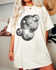 Comfort Colors Retro Disco Ball Oversized Tee Perfect for a Brides Last Disco Themed Bachelorette Party Or Any Fun Club Tee Machine wash inside out with like colors. Tumble dry on low to medium heat. Do not iron directly on image. Please refer to size chart for reference before purchasing. If you want an oversized fit, go up 1-2 sizes. Please feel free to message with any questions. Please note, since items are made to order, we do not accept cancellations, returns or exchanges. Please make sure all sizing and shipping information is correct before placing an order! Mockups are used for demonstration purposes only, and the final product may vary slightlty in color and placement due to printing and computer monitors. Disco Bachelorette Party T-shirts & Tank Tops, Chromatica Ball T Shirt, Relaxed Fit Cotton Party Tops, Relaxed Fit Cotton Tops For Party, Oversized Casual Party Top, Oversized Casual Top For Parties, Party Cotton Tops With Screen Print, Relaxed Fit Cotton T-shirt For Party, Disco Style Cotton Short Sleeve Tops