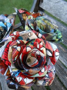 several paper flowers sitting on top of a wooden bench