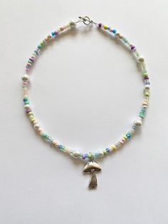 "️🍄 𝓰𝓾𝓶𝓭𝓻𝓸𝓹 𝓰𝓪𝓻𝓭𝓮𝓷 𝓷𝓮𝓬𝓴𝓵𝓪𝓬𝓮 ️🍄 FREE SHIPPING You will receive one necklace as seen in photos. Has a pastel rainbow and white color scheme. Made to order and beaded by me with luvvv <3 Strung on strong cord with a mixture of glass beads!! 🌹 Silver toggle clasp closure. Each necklace is unique with a different bead pattern but will look similar to photos. Looks great alone or layered with our mushroom garden necklace. Necklace variations - please choose when purchasing ( Cute Pastel Beaded Jewelry, Handmade Pastel Whimsical Jewelry, Whimsical Pastel Handmade Jewelry, Pastel Whimsical Handmade Jewelry, Handmade Multicolor Fairycore Jewelry, Trendy Beaded Necklace, Rainbow Fairy, Pastel Necklace, Necklace Fairy