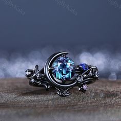 a ring with a blue topazte surrounded by silver filigrees on a wooden surface