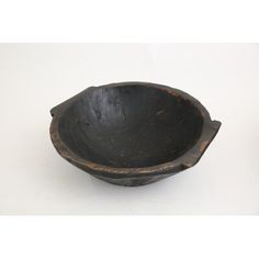 an old wooden bowl sitting on top of a white table