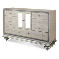 a white dresser with mirrored doors and drawers on it's sides, against a white background