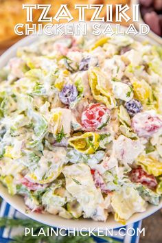 a white bowl filled with salad next to olives and bread