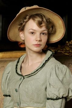 a woman wearing a hat sitting on top of a couch