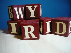 wooden blocks spelling the word bride on top of each other in front of a blue background