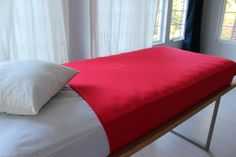 a red and white bed with two pillows on it