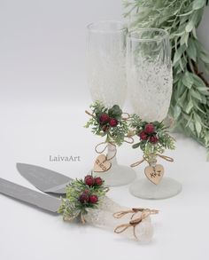 two wine glasses are sitting next to each other with flowers and hearts attached to them