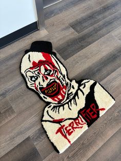 a rug with the image of a creepy clown on it is laying on the floor