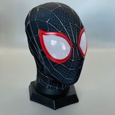 a spider - man mask with glowing eyes on top of a black headdress