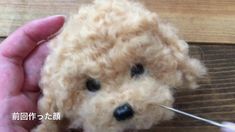 a person is holding a needle in front of a teddy bear that has been crocheted