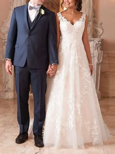 a bride and groom holding hands in front of a fireplace