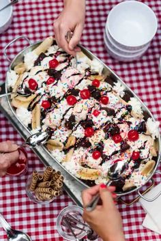 people are serving desserts at a table with red and white checkered tables cloth