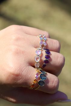 Okay everyone needs one of these in their lives. I'm dead serious. It is one of the prettiest rings ever and it goes with everything. This ring features a variety of different oval-shaped sapphires ranging in color from orange to violet set in 18K solid gold. This ring can also be made in certain colors/patterns. Please get in touch with us for custom orders at marena@jewelsbymarena.com. Please allow up to 3 weeks for shipping once order is placed as each piece is handmade to order. Multicolor Oval Amethyst Ring With Gemstone Accents, Fine Jewelry Oval Gemstone Stackable Rings, Multicolor Oval Sapphire Ring, Multi-stone Stackable Rings, Multicolor Oval Amethyst Ring, Oval Purple Sapphire Rings, Multicolor Oval Amethyst Gemstone Ring, Purple Sapphire Oval Ring, Oval Multi-stone Sapphire And Topaz Ring