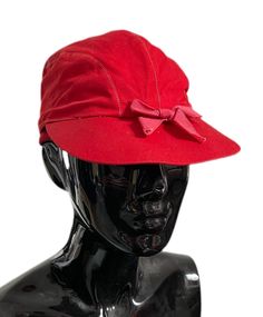 a mannequin head wearing a red hat with a bow on it's brim