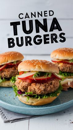 two tuna burgers with lettuce and tomatoes on a blue plate next to the words canned tuna burgers