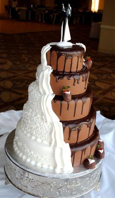 a three tiered wedding cake with chocolate icing and white frosting on top