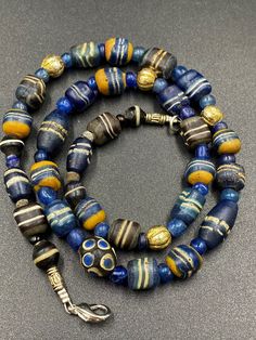 Ancient blue color roman glass beads from ancient roman empire . The origin of this beads from Afghanistan . some Wax gold plated beads used as counter beads we provide fast and free shipping to our customers by which can get the items by 7 maximum working days Bohemian Single Strand Gold Beads, Handmade Gold Amulet Beads, Handmade Gold Beads For Amulets, Unique Gold Glass Beaded Necklaces, Unique Gold Beaded Glass Necklaces, Artisan Single Strand Gold Beads, Artisan Gold Single Strand Beads, Gold Amulet Style Beaded Necklace With Round Beads, Handmade Gold Glass Beads