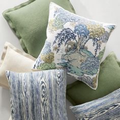 four pillows stacked on top of each other in different colors and patterns, all with trees printed on them