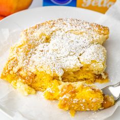 a white plate topped with a piece of cake and powdered sugar on top of it