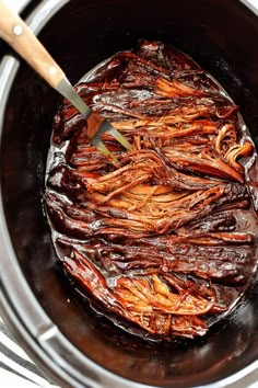 the food is being cooked in the crock pot with a spatula on top