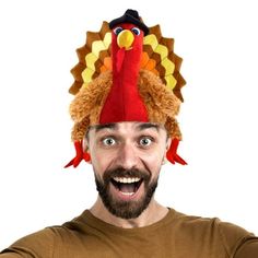 a man with a turkey hat on his head is making a funny face at the camera