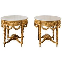 a pair of tables with marble top sitting next to each other on either side of the table