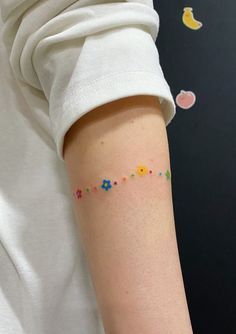 a person with a small tattoo on their arm that has flowers and stars all over it